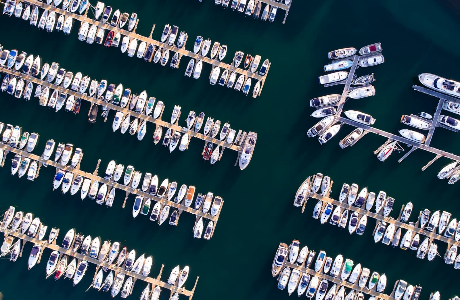 Aerial view of marina pontoons lined with boats