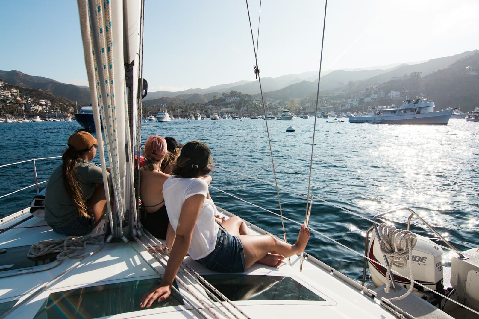 Crew sitting on the bow of a sailing yacht